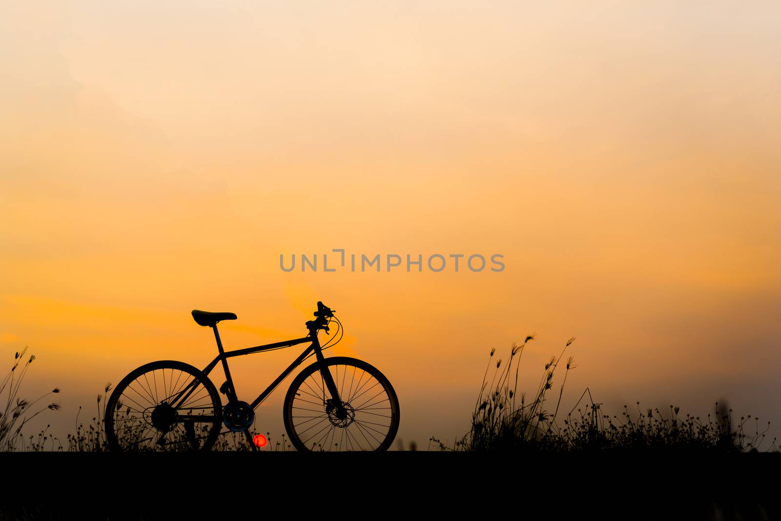 Sunset silhouette and bicycle on beautiful sky by anatskwong