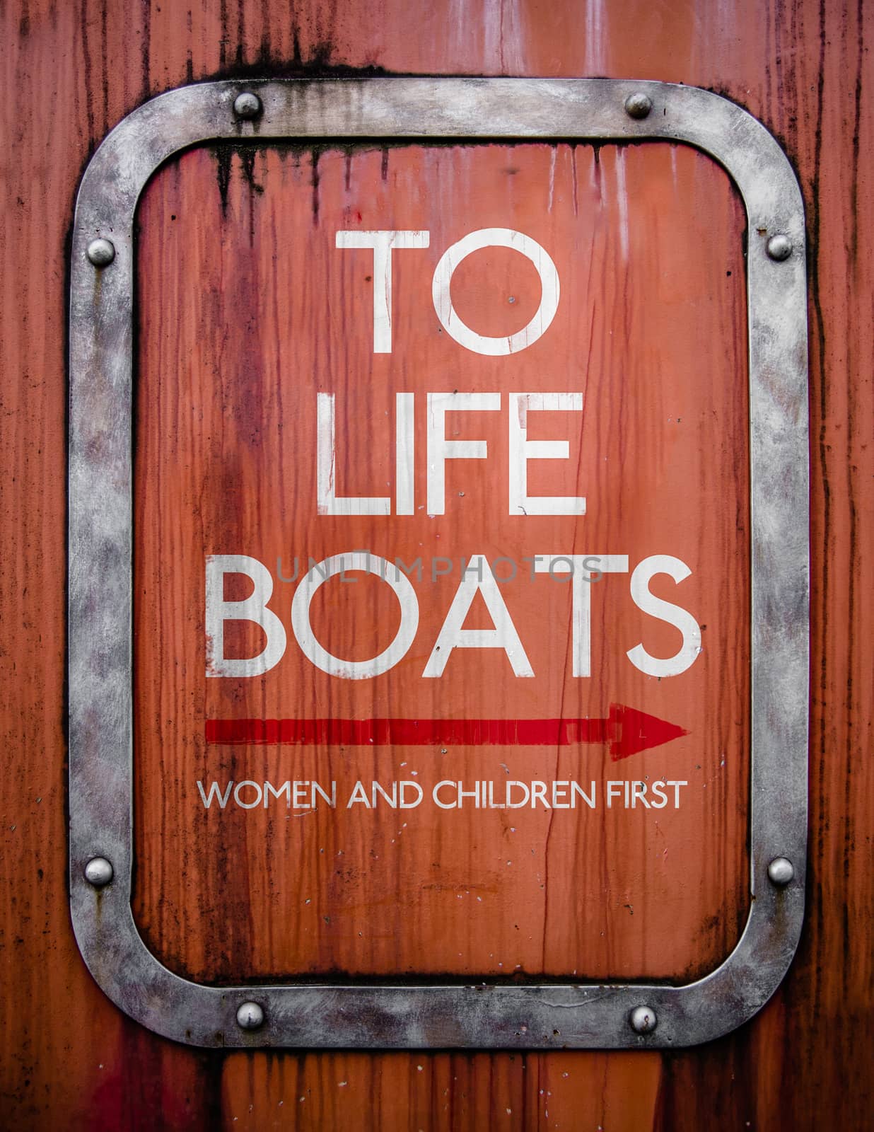 A Grungy Sign Pointing To Life Boats On An Old Ship