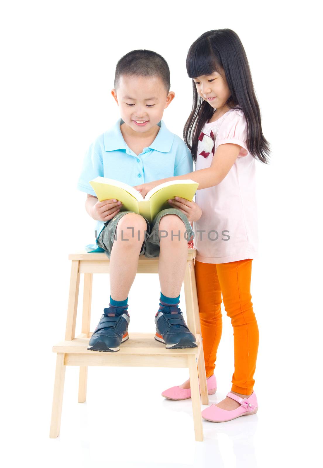 Cute asian boy and girl reading a book