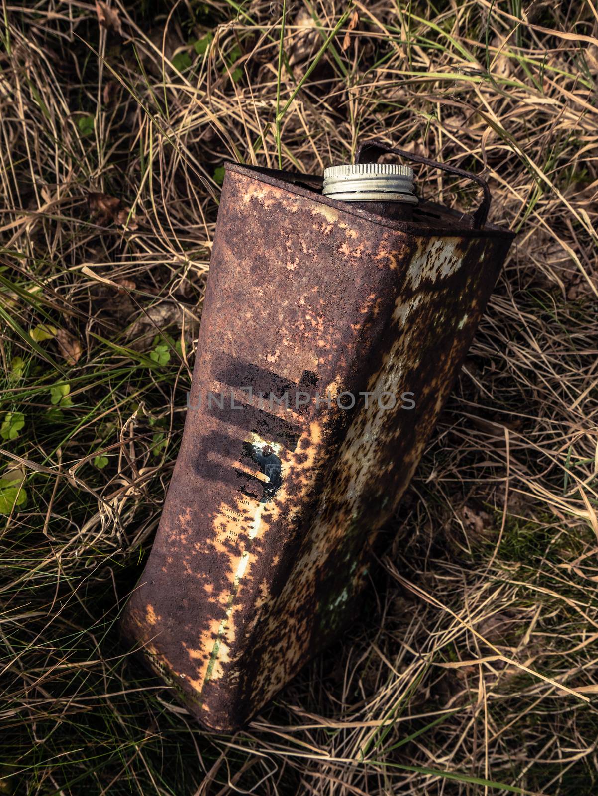 Conceptual Image Of An Old Rusty Oil Can Abandoned In The Undergrowth