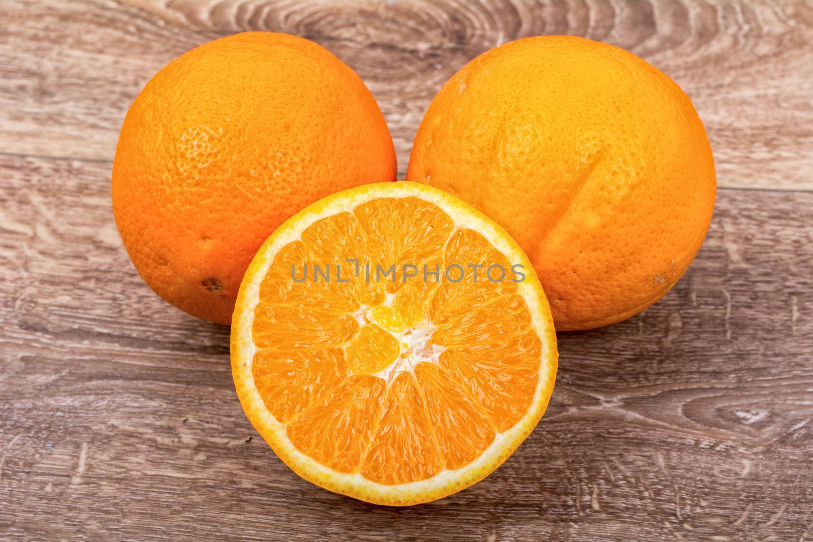The orange oranges on a brown wooden background