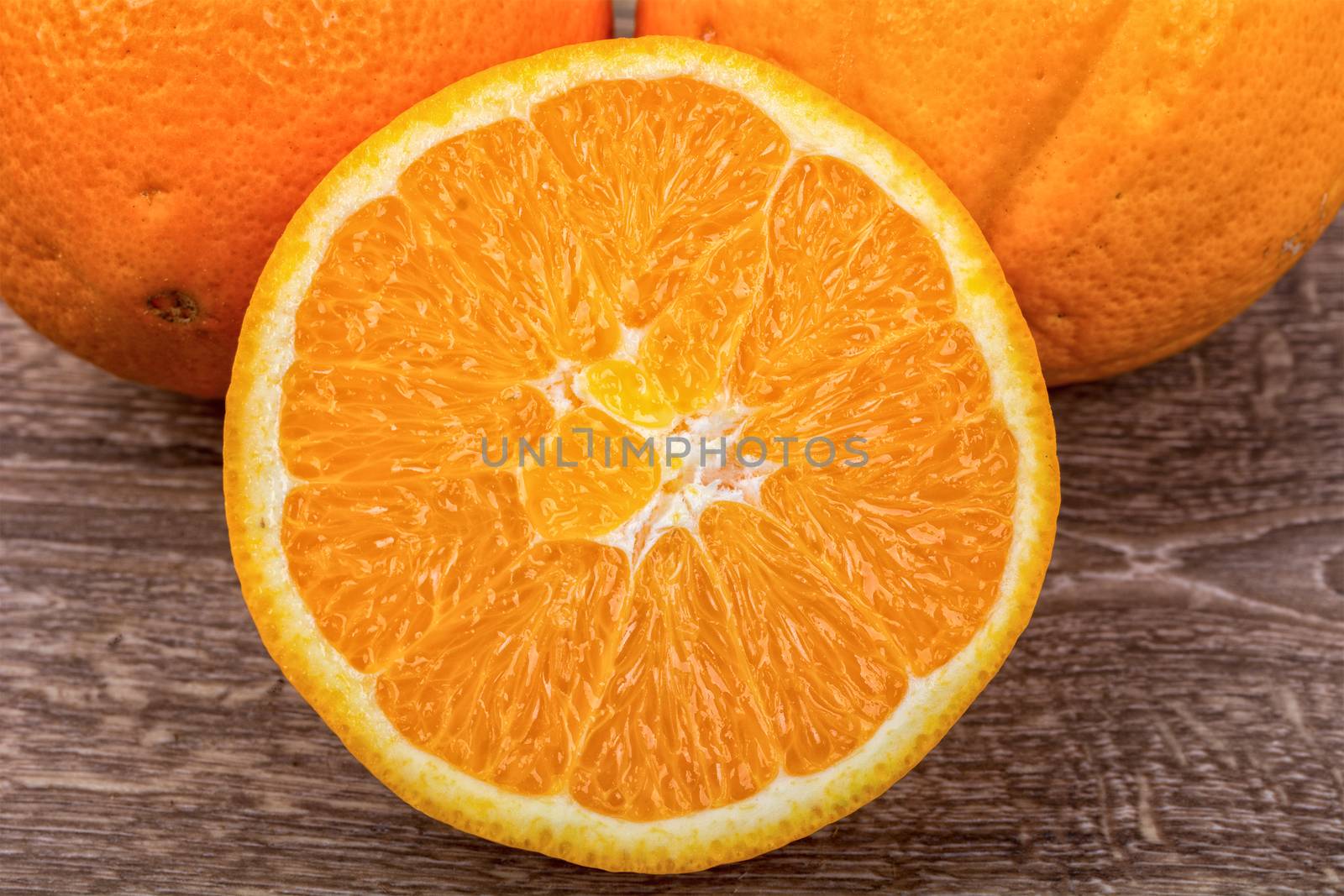 The orange oranges on a brown wooden background