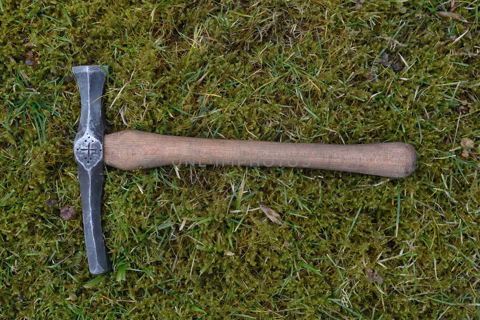 Hand made blacksmith hammer lying on the grass