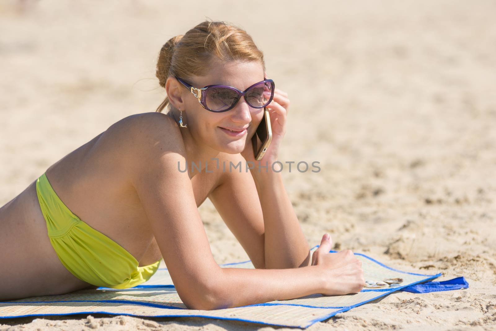 Young beautiful woman sunbathing on the sandy beach