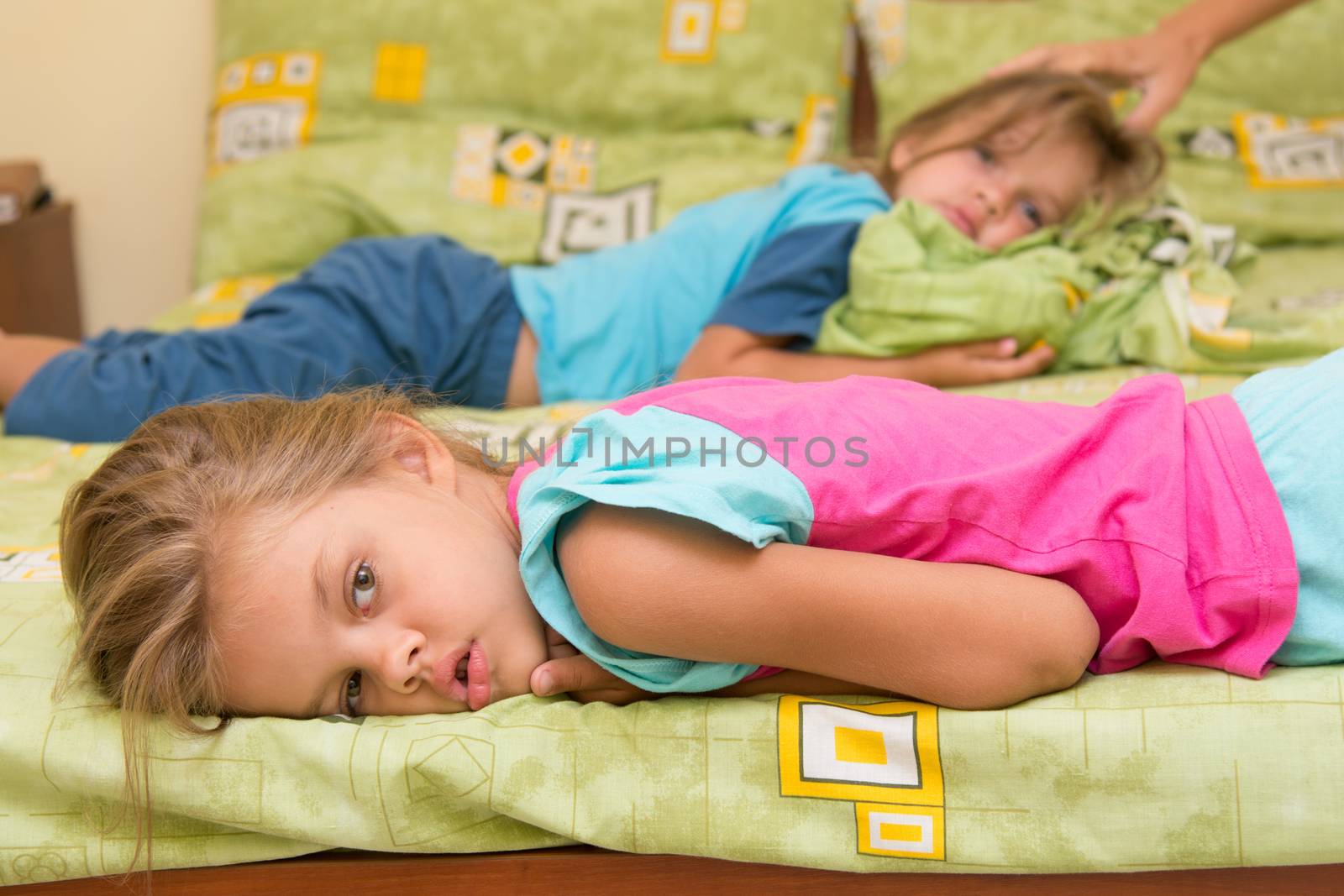 Two girls woke up lying in bed turning heads in different directions