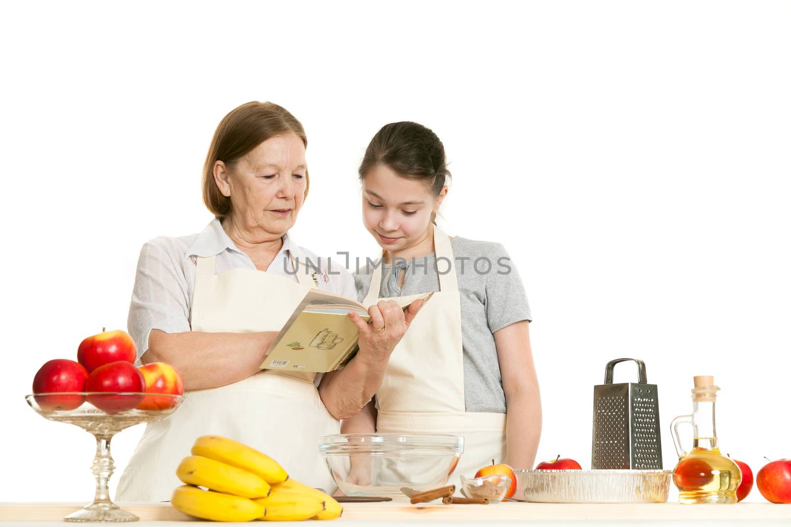 the grandmother and the granddaughter read the recipe-book before cooking of food