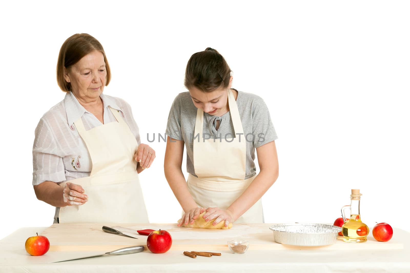 the grandmother and the granddaughter knead dough on a kitchen table