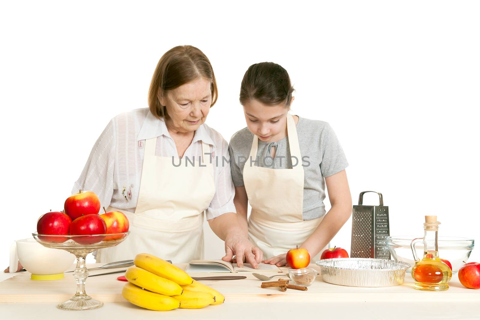 the grandmother and the granddaughter read the recipe-book  by sveter