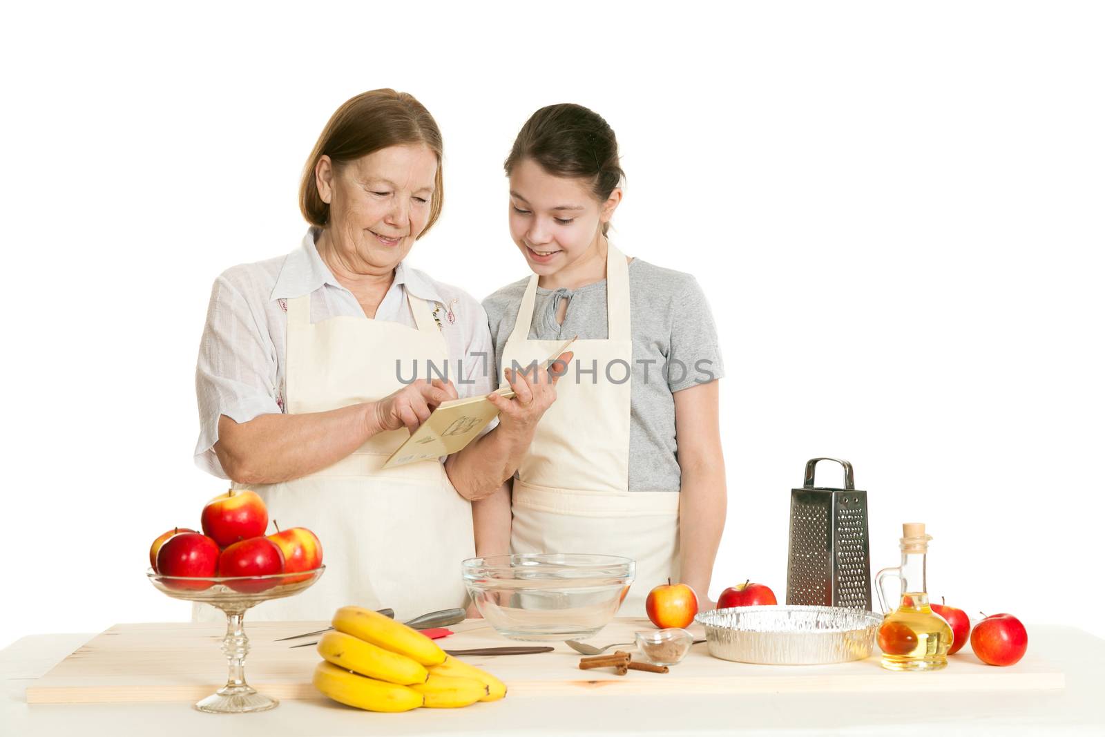 the grandmother and the granddaughter read the recipe-book before cooking of food