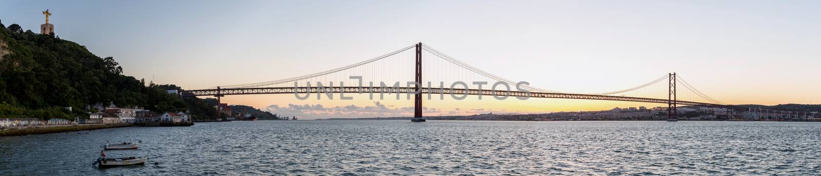 Panorama of Lisbon cityscape with 25 de Abril suspension Bridge, Portugal at dusk