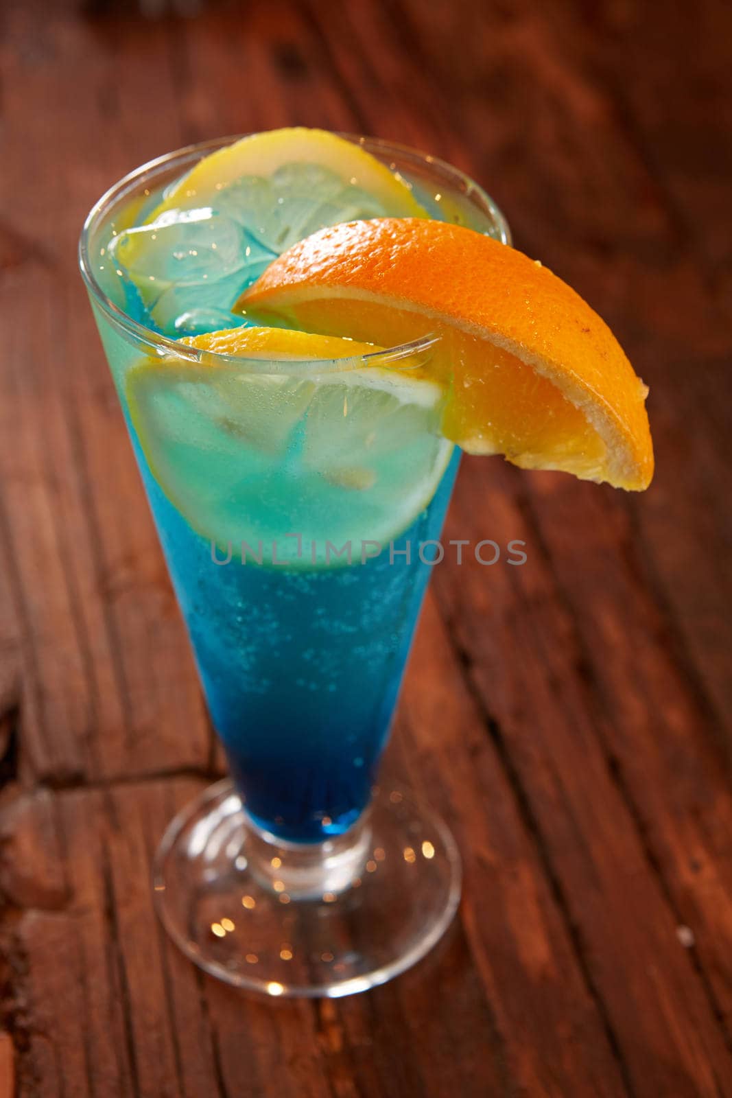 Fresh cocktail with blue curacao on wooden table