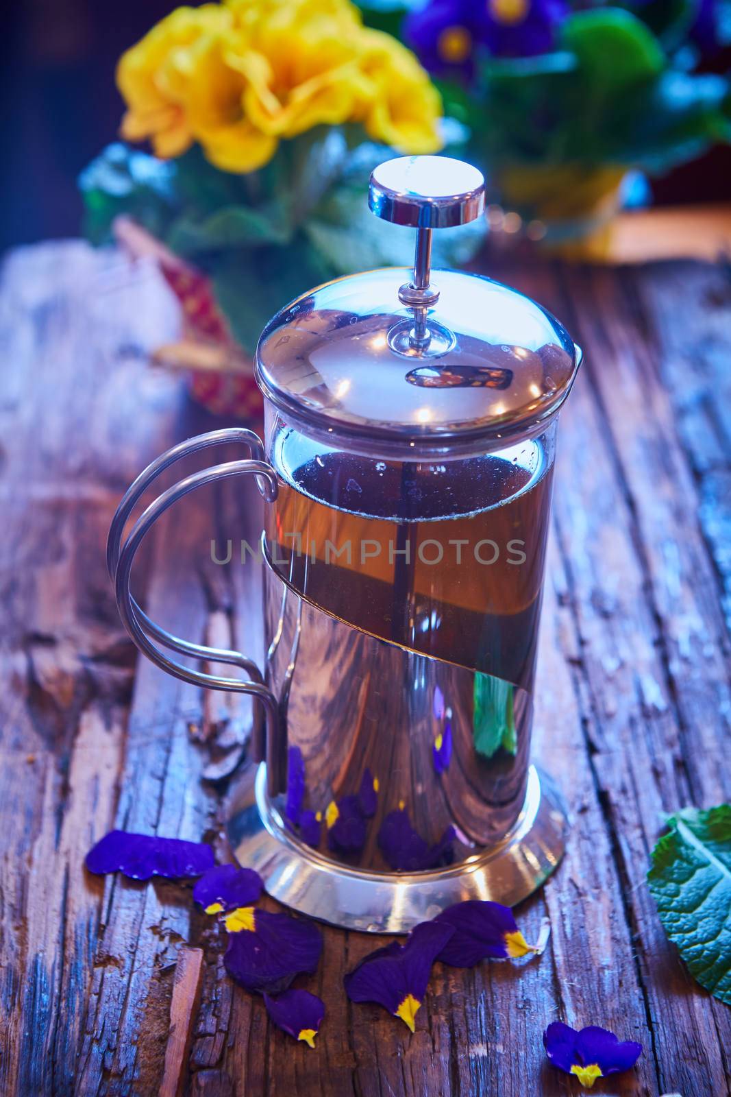 Flower tea in glass pot on a wooden table. spring concept