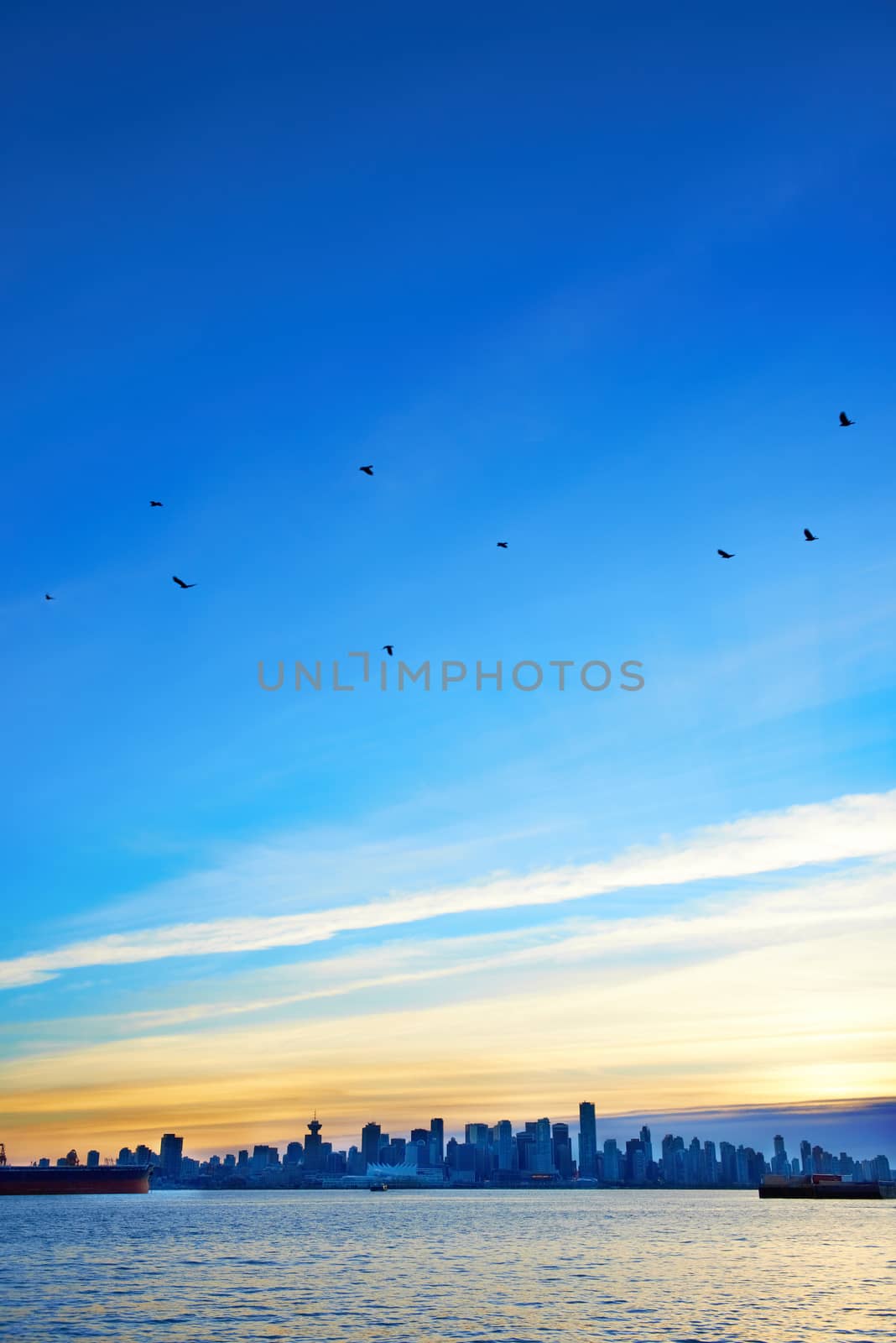 Night city, panoramic scene of downtown reflected in water. Sunset above Vancouver, Canada