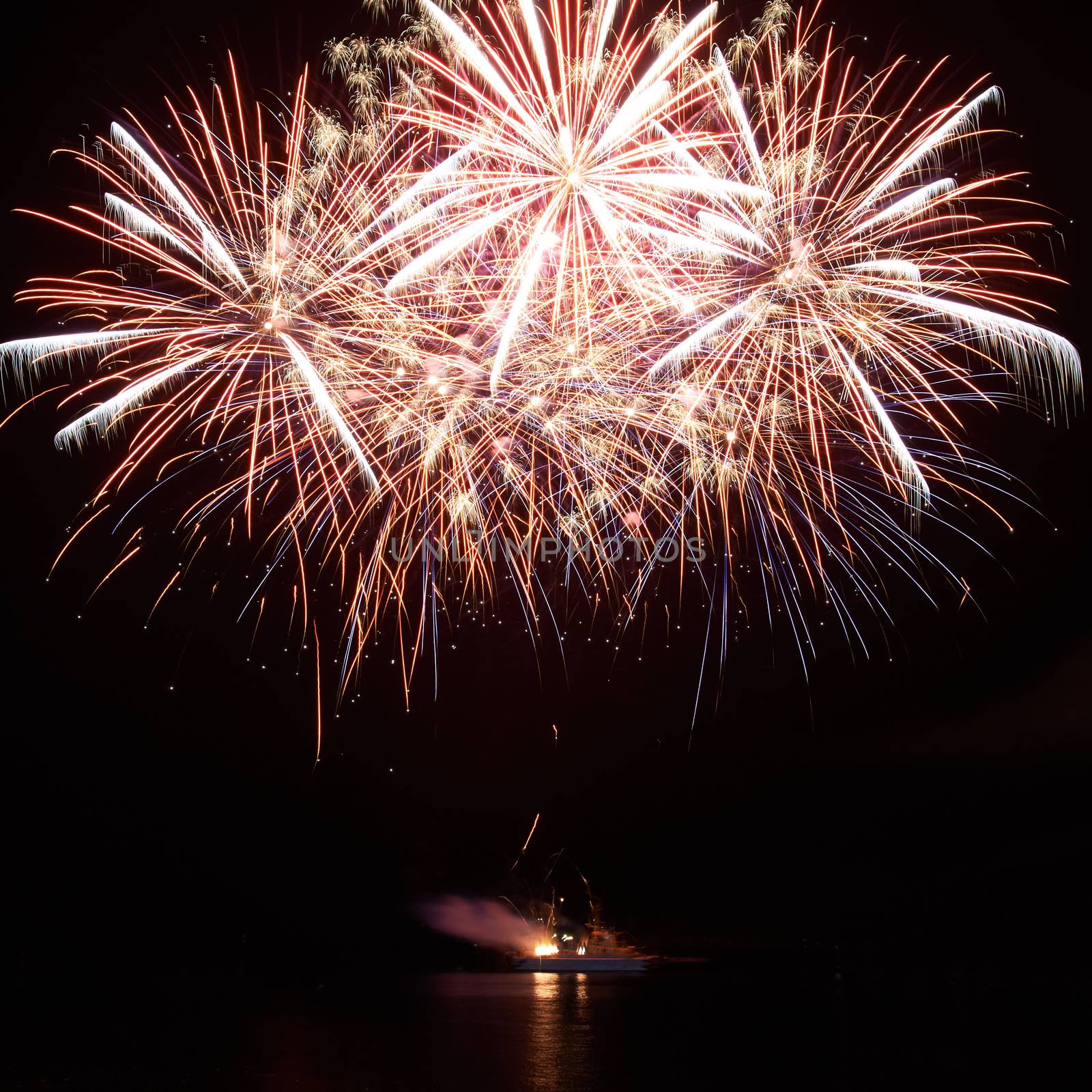 Red colorful holiday fireworks on the black sky background.