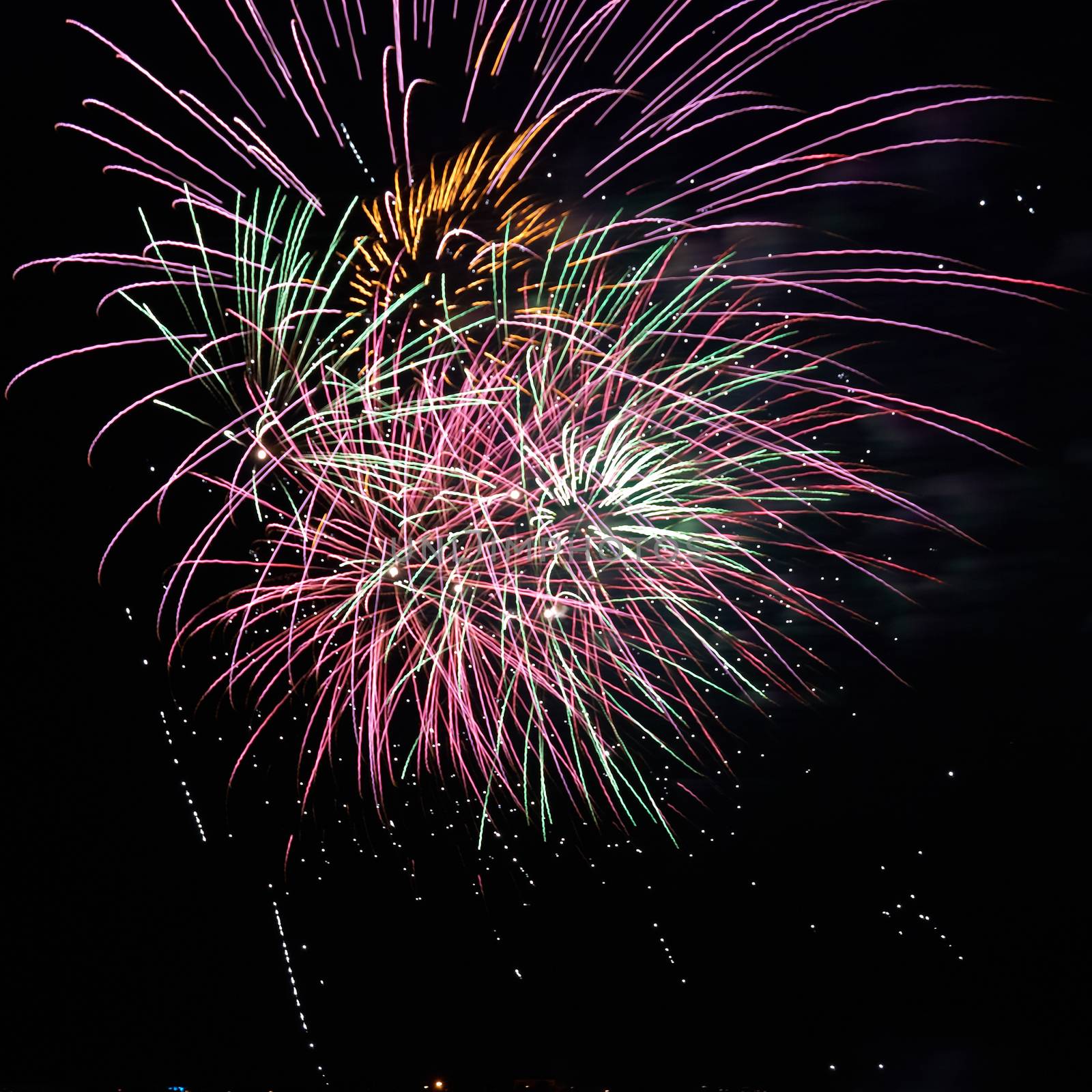 Blue, red and yellow colorful holiday fireworks on the black sky background.