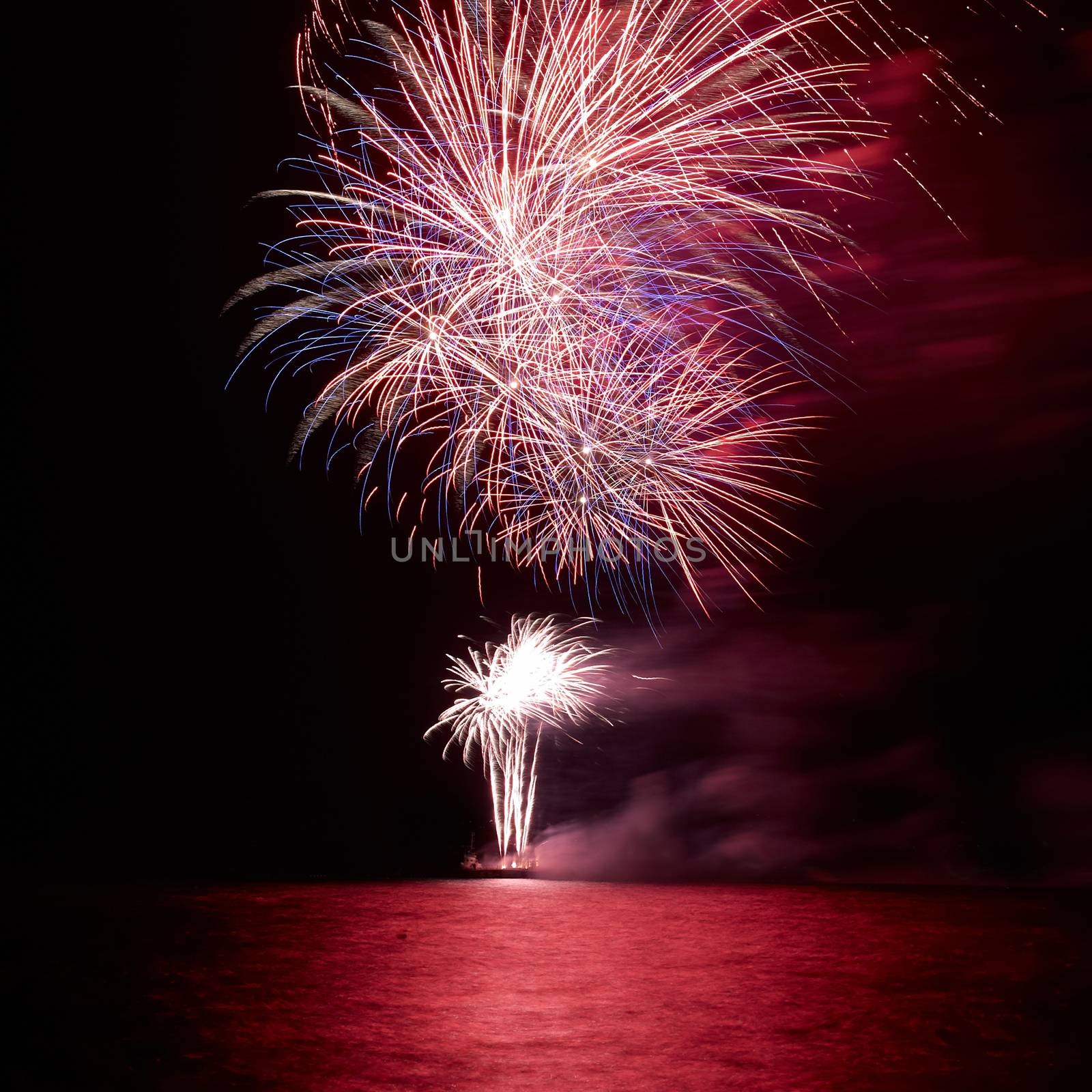 Red colorful holiday fireworks on the black sky background.