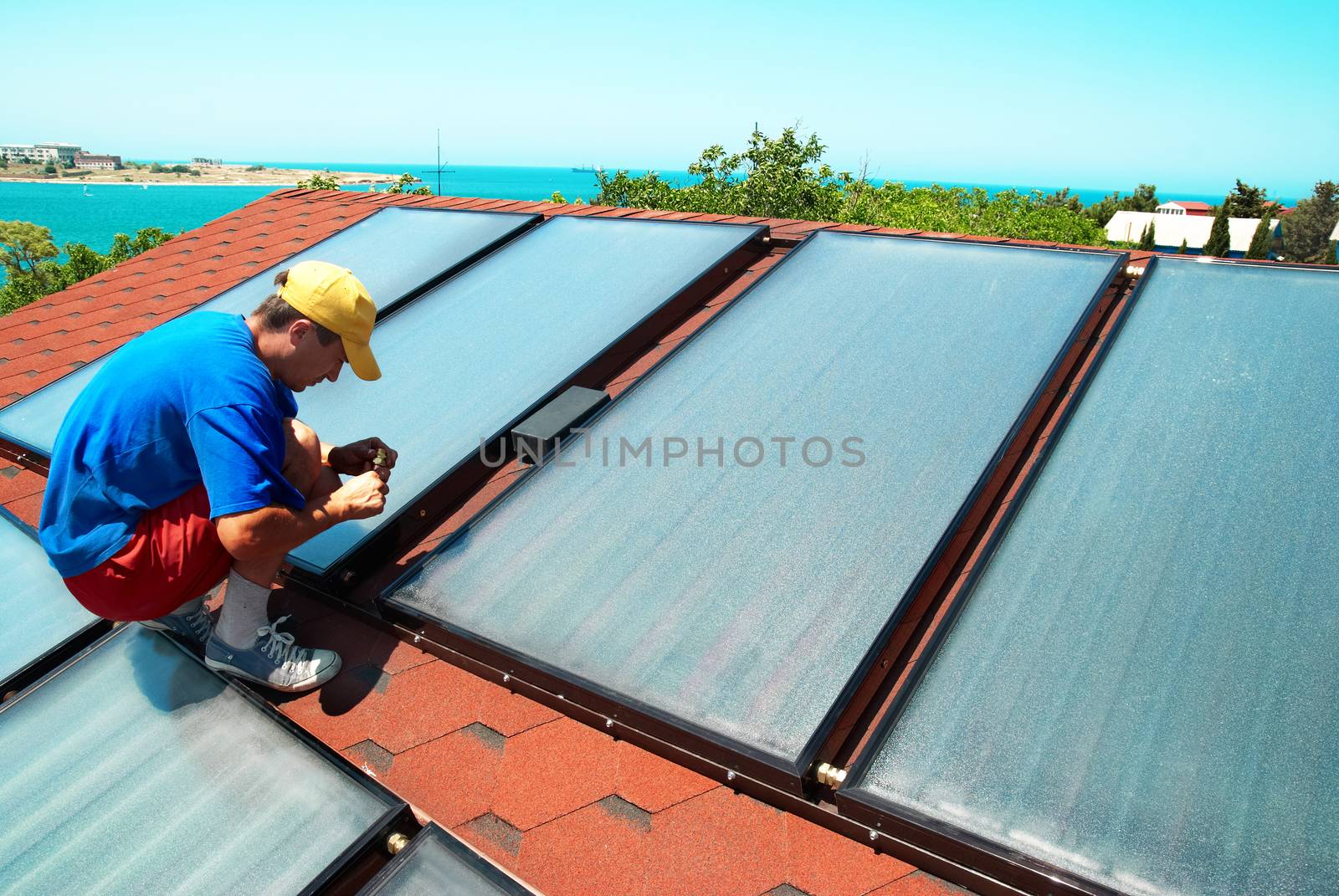 Worker installs solar panels by vapi