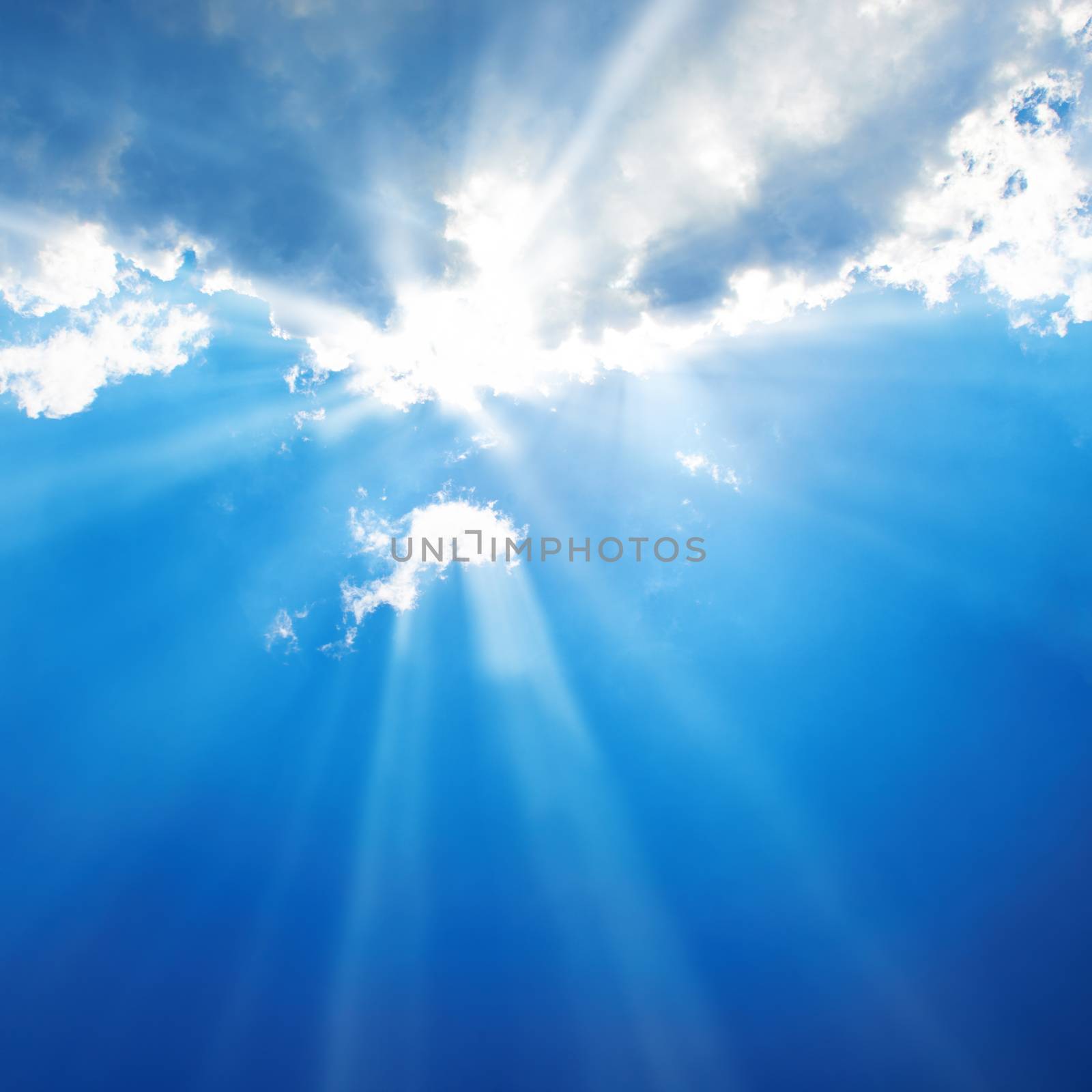 Beautiful blue sky with sunbeams and clouds. Sun rays.