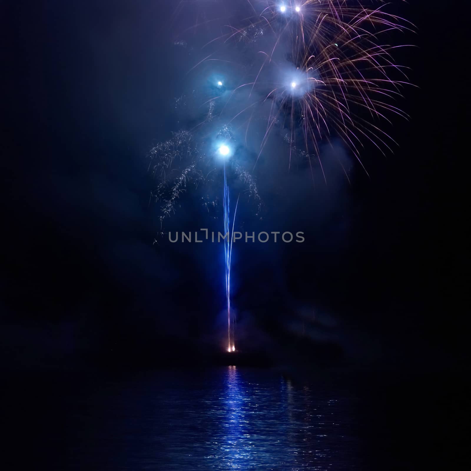 Blue colorful fireworks on the black sky background. Holiday celebration.