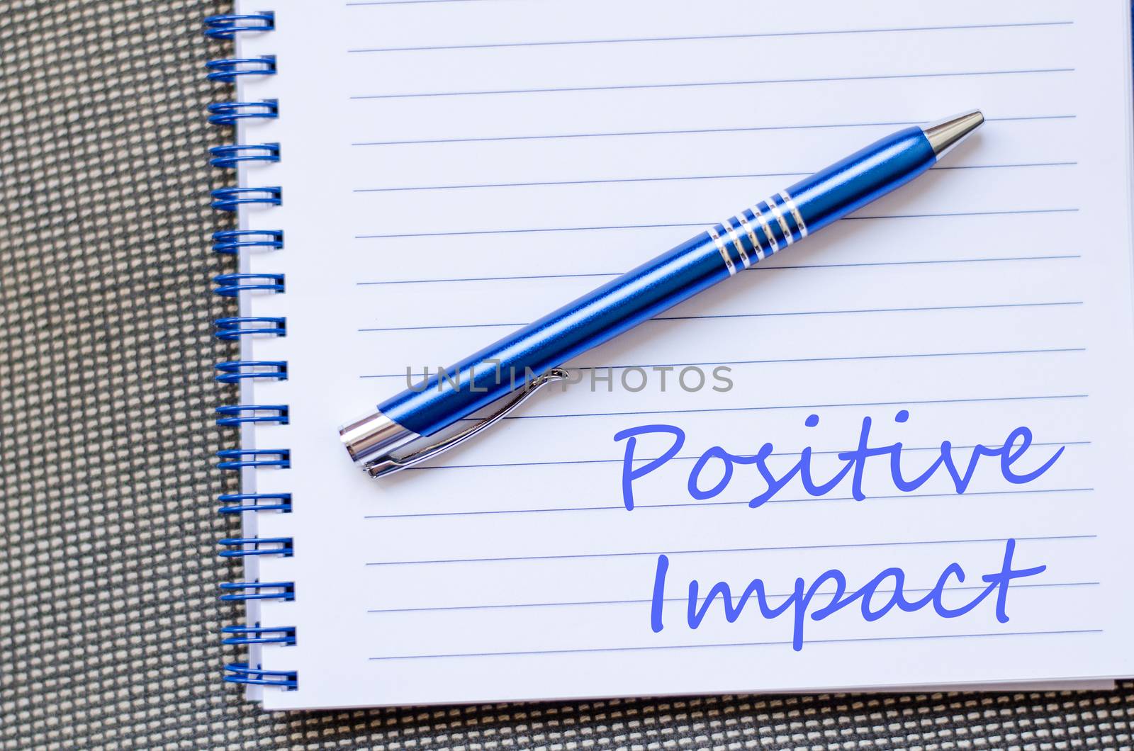 Positive impact text concept write on notebook with pen