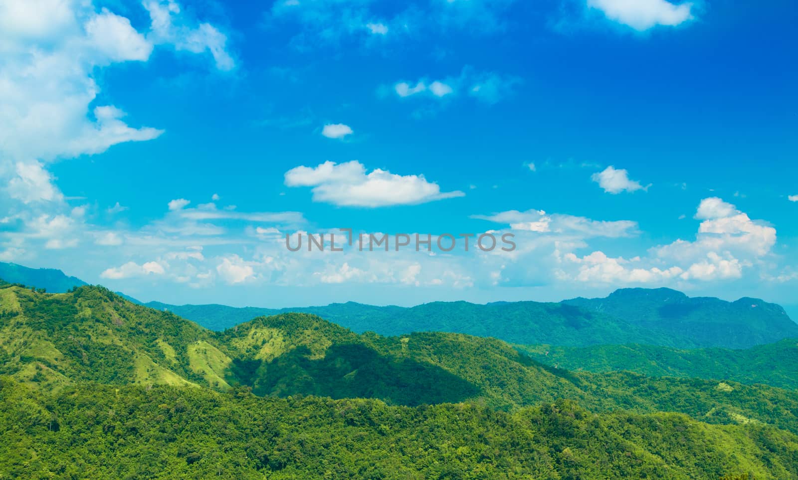Green mountain with blue sky and clouds background