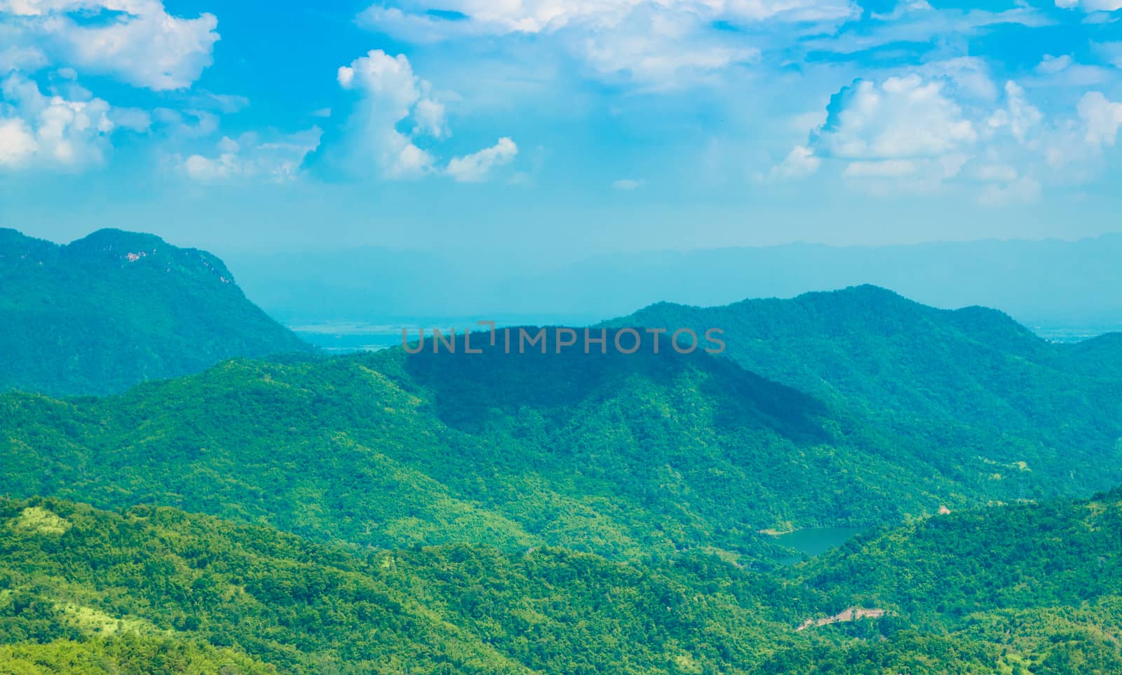 Green mountain with blue sky and clouds background
