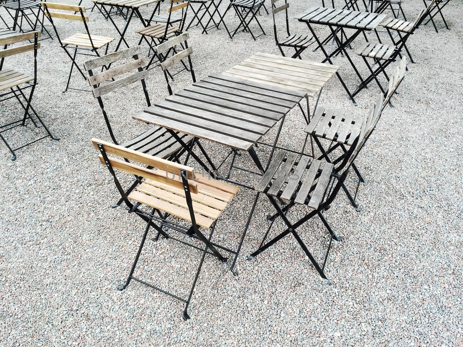 Outdoor cafe with wooden tables and chairs.