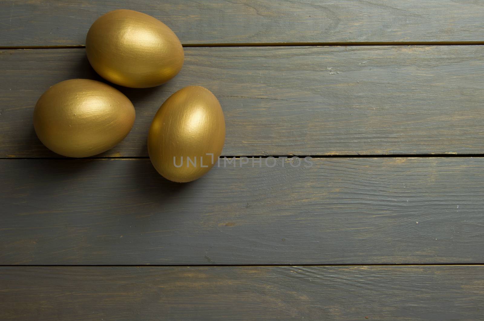 Gold eggs over a wood background