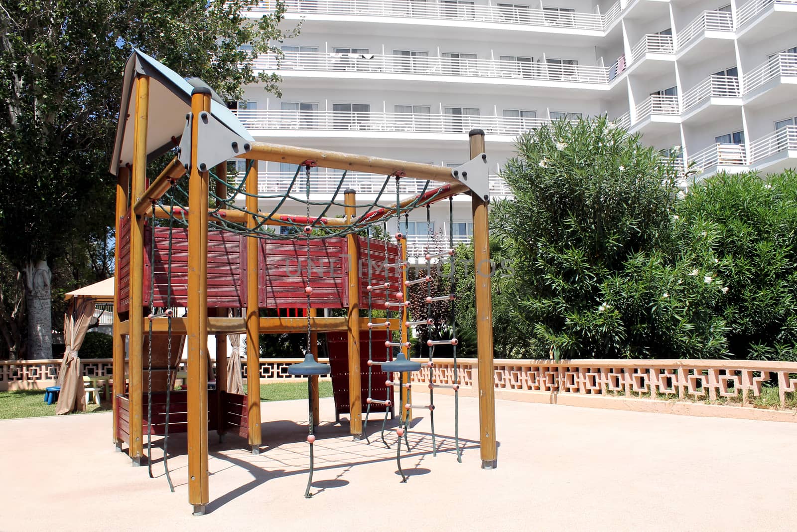 Childrens play park in the grounds of a modern hotel building.