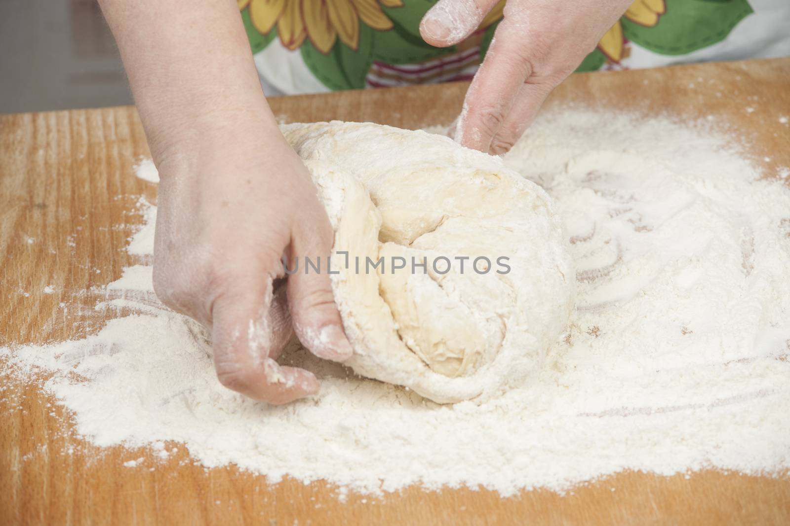 Women's hands prepairing fresh yeast dough.