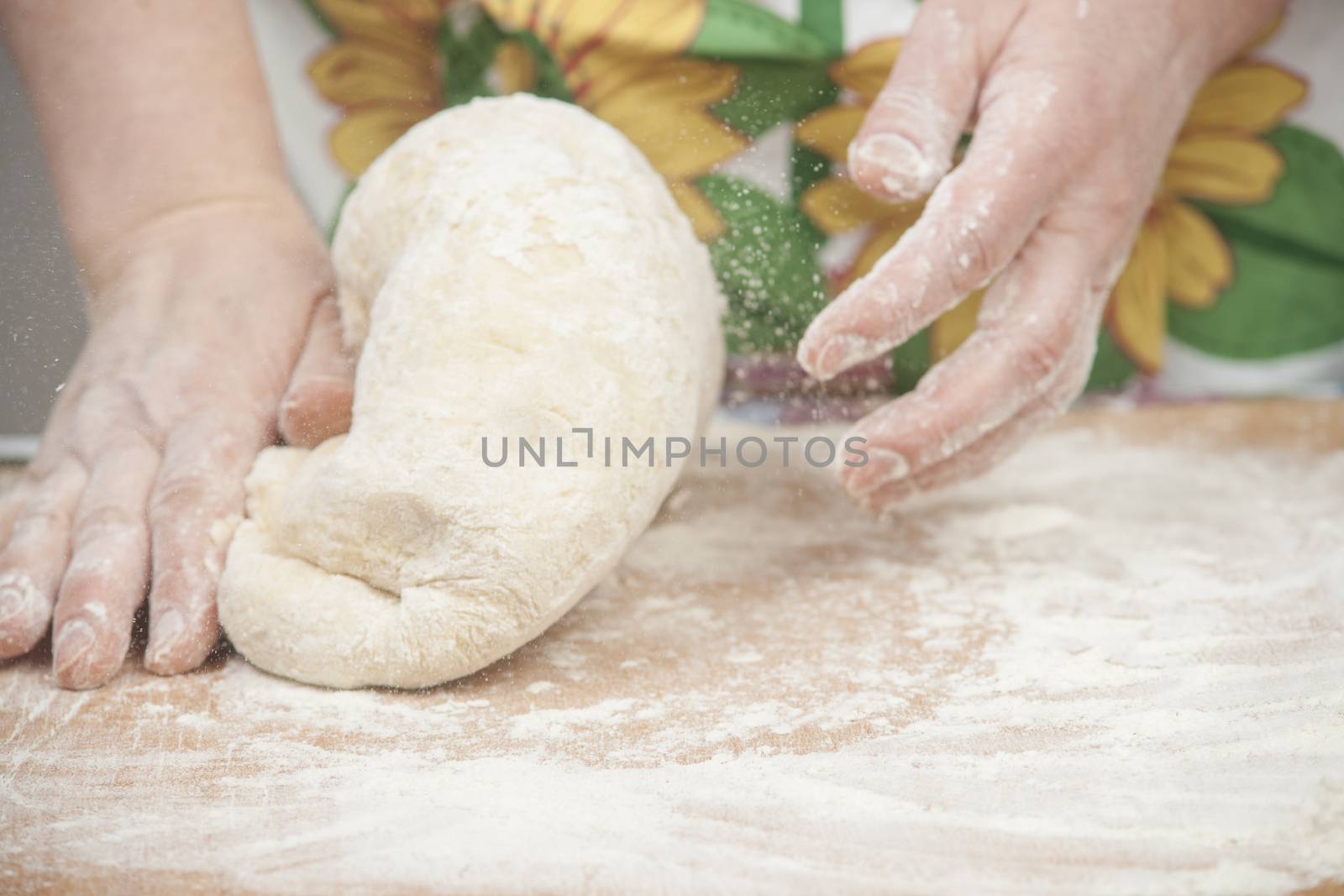 Women's hands preparing fresh yeast dough.