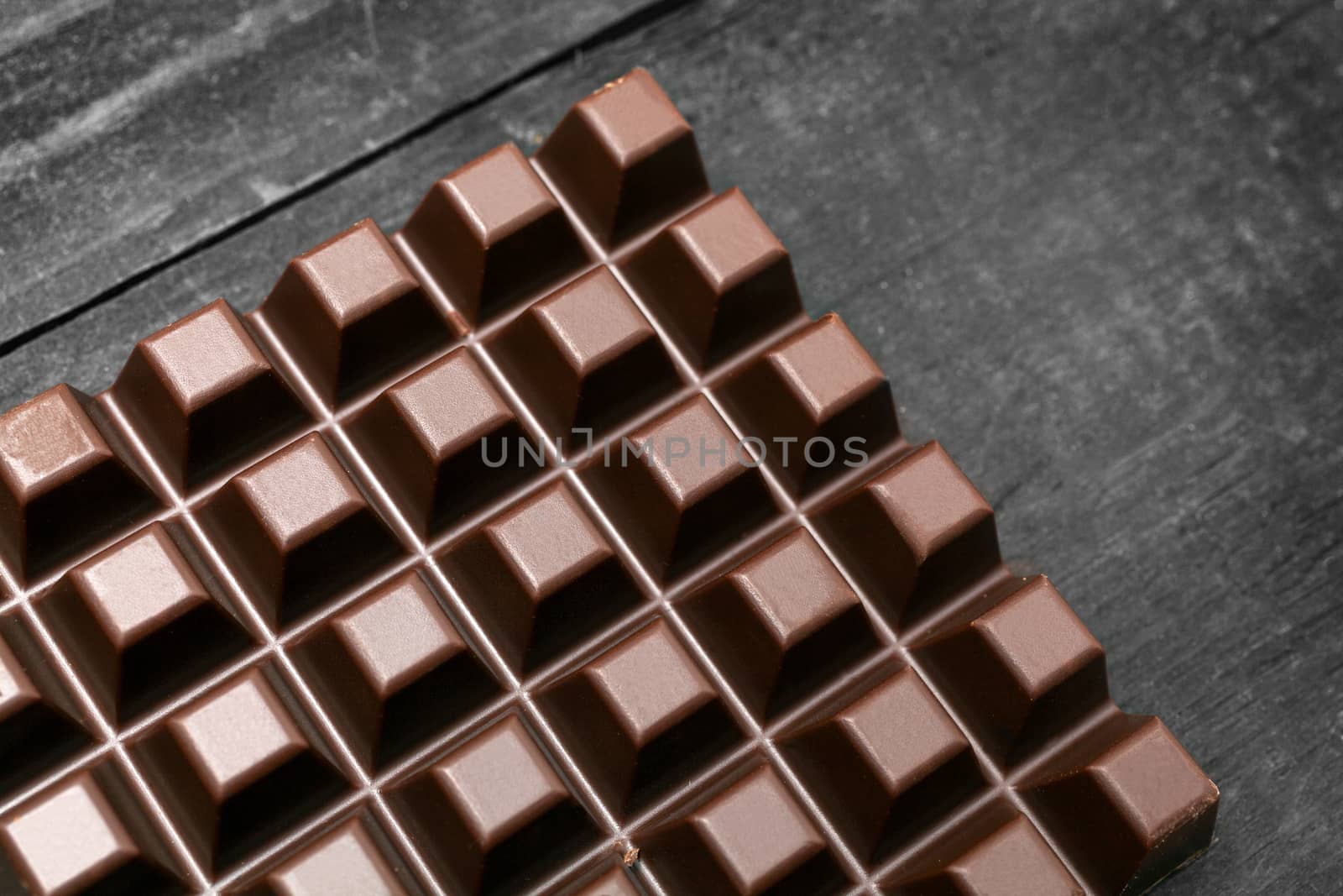Dark chocolate bar on wooden background