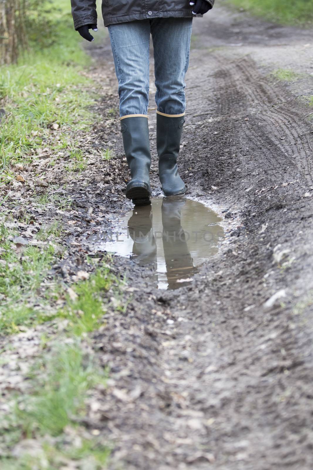 Man woman with rubber boots walking on rural path