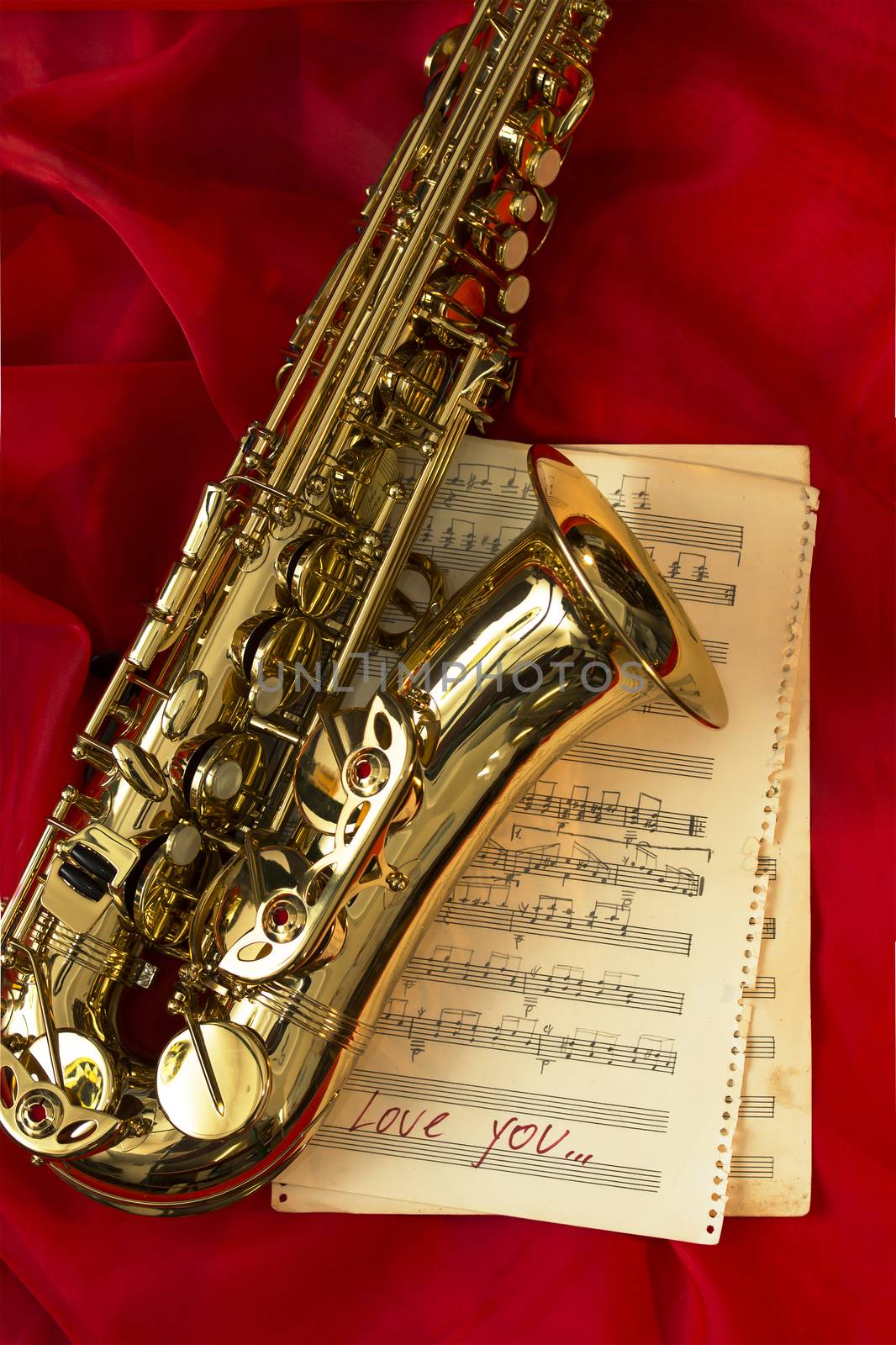 Golden saxophone and music sheets on a red background