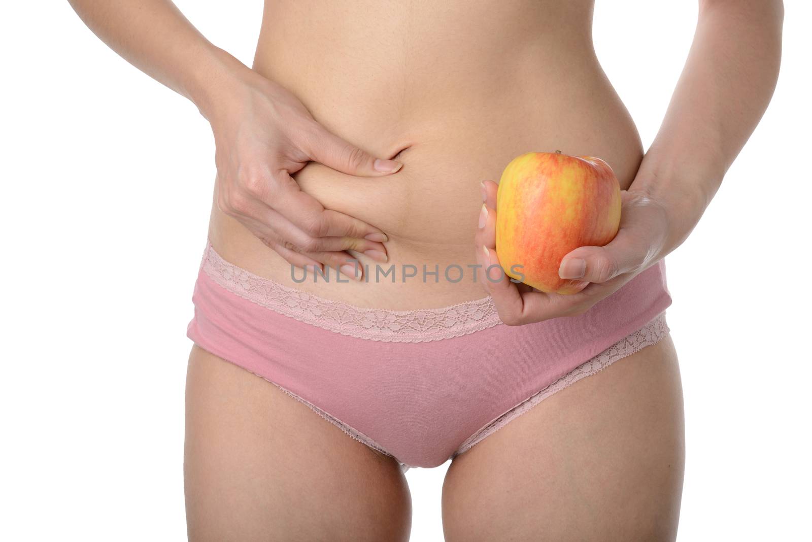 Beautiful slim woman holding fresh apple while checking her fat,Diet concept