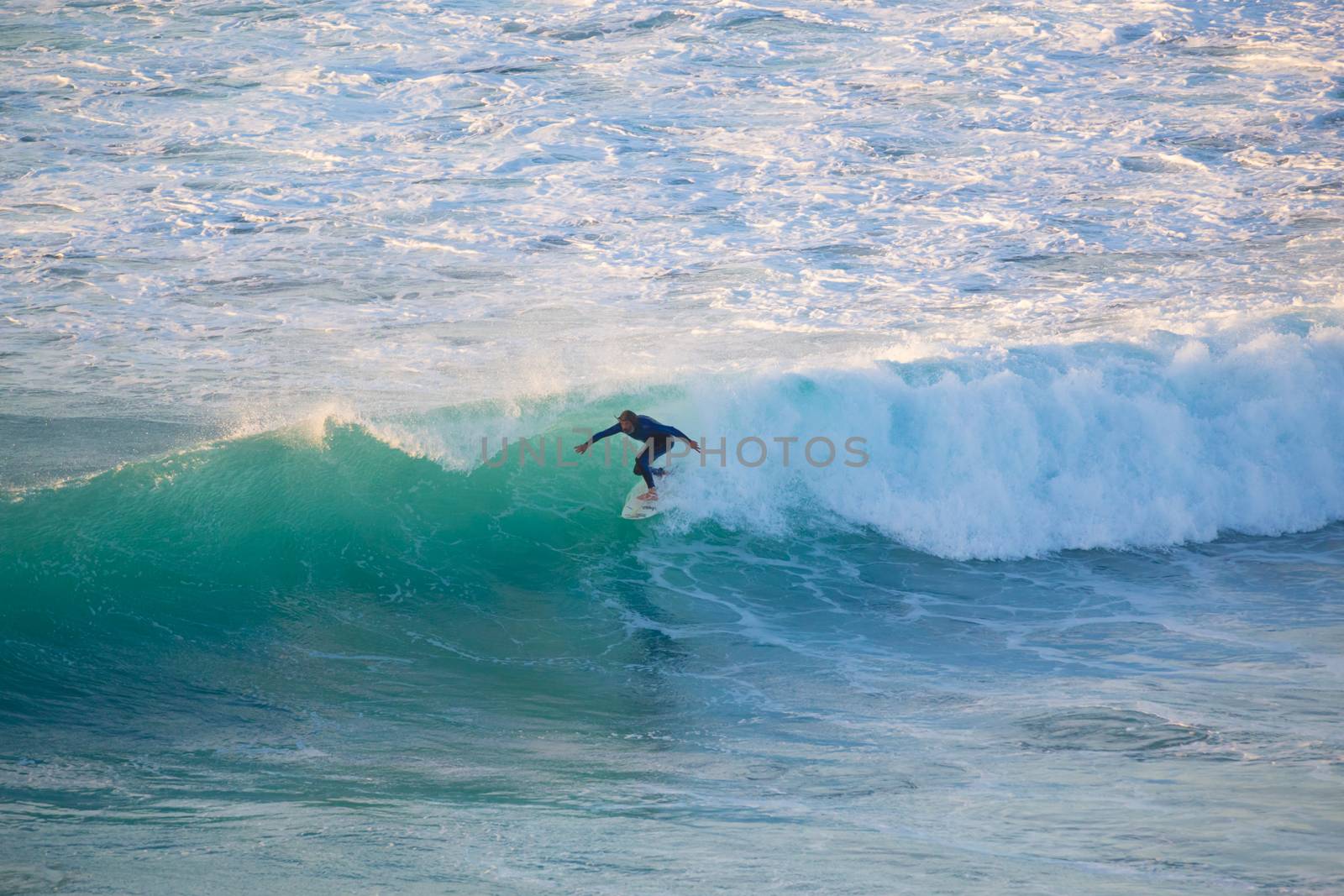 La Pared, Spain - Dec 23, 2015:  Active sporty senior surfer riding perfect wave on La Pared beach, famous surfing destination on Fuerteventura, Canary Islands, Spain on December 23, 2015. 