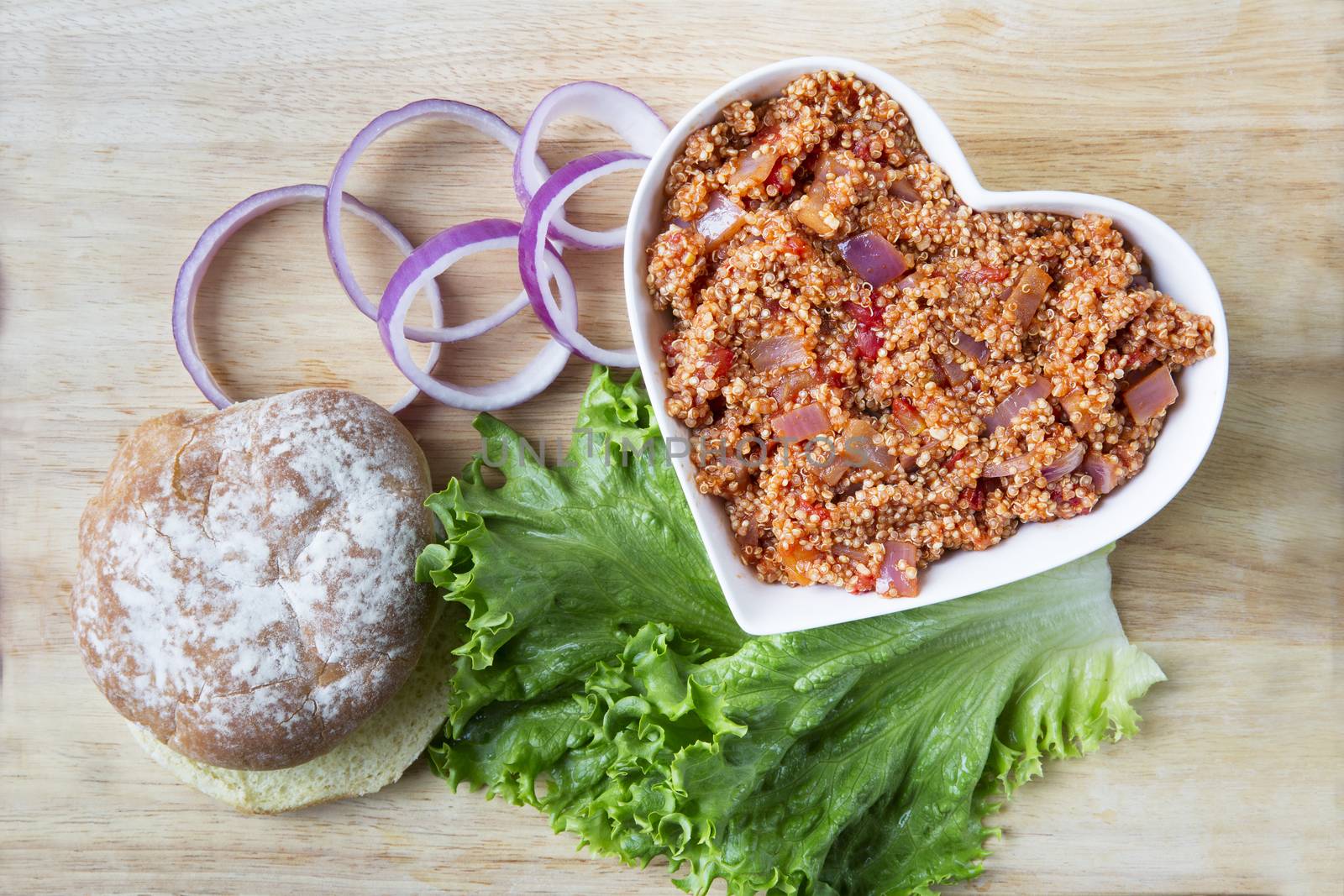 Heart healthy vegan sloppy joe sauce made with quinoa, with a bun, lettuce and onion.
