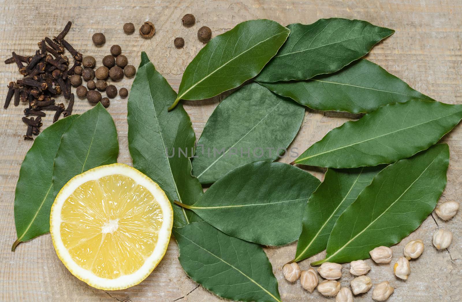 Half a lemon, Bay leaf, spices, lying on the old Board by Gaina