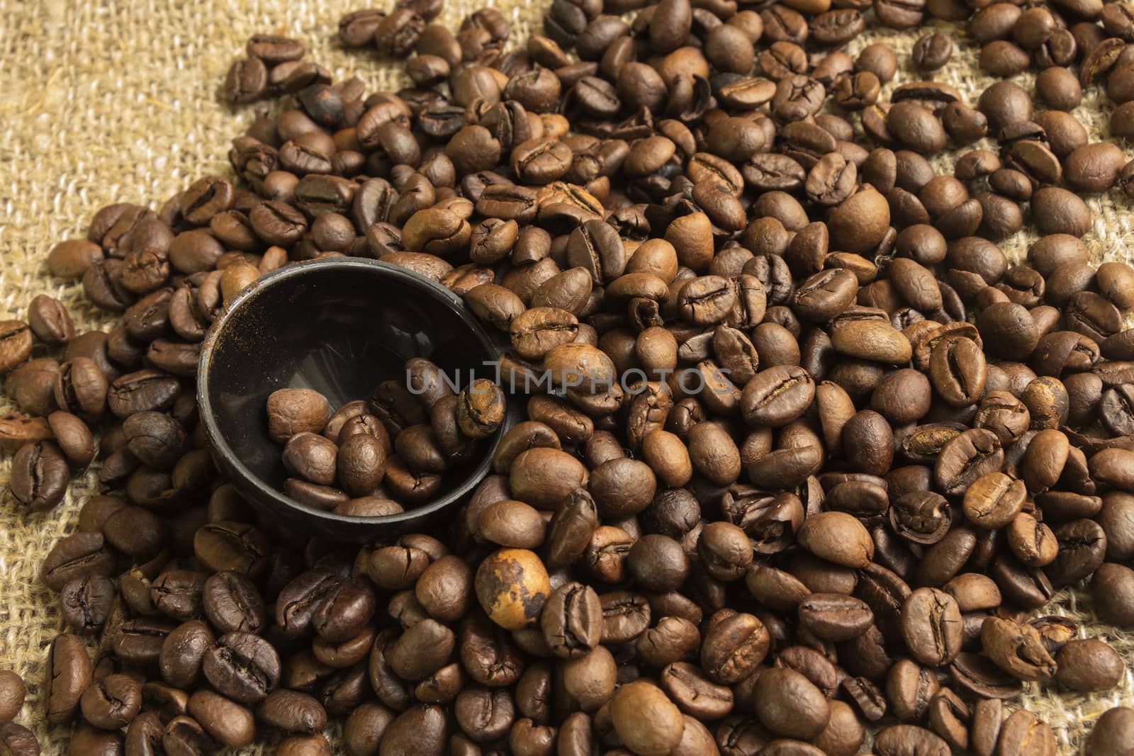 canvas background with coffee roasted grains and Brown spoon