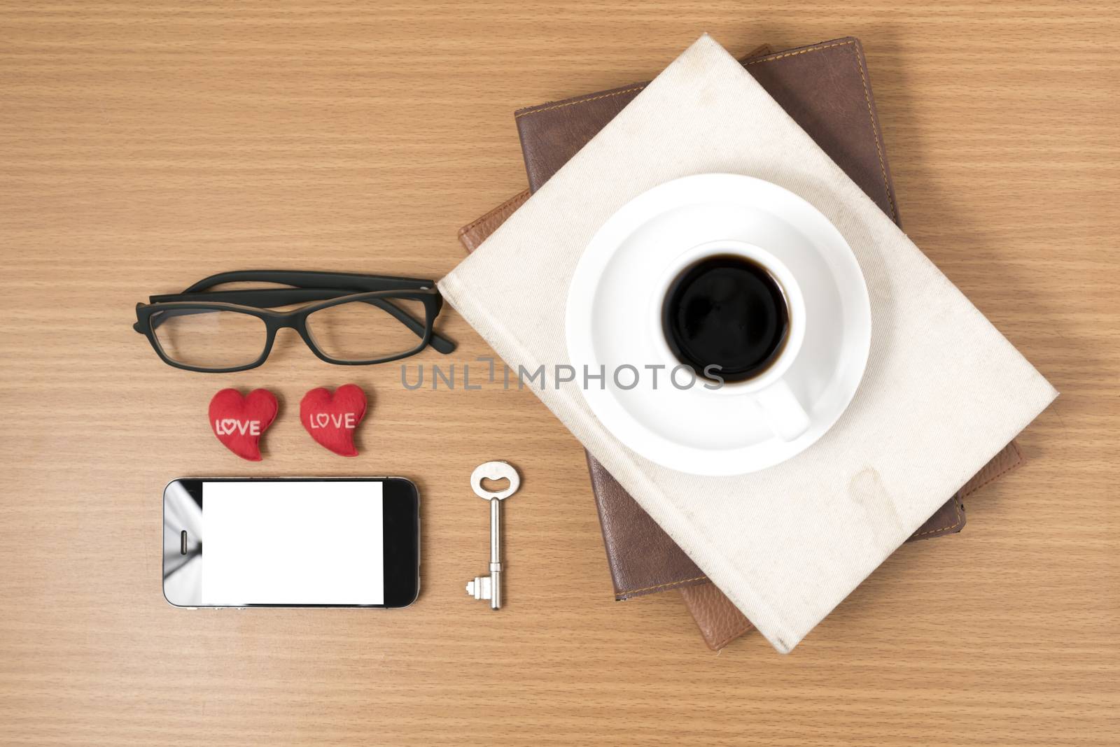 office desk : coffee and phone with key,eyeglasses,stack of book,heart on wood background