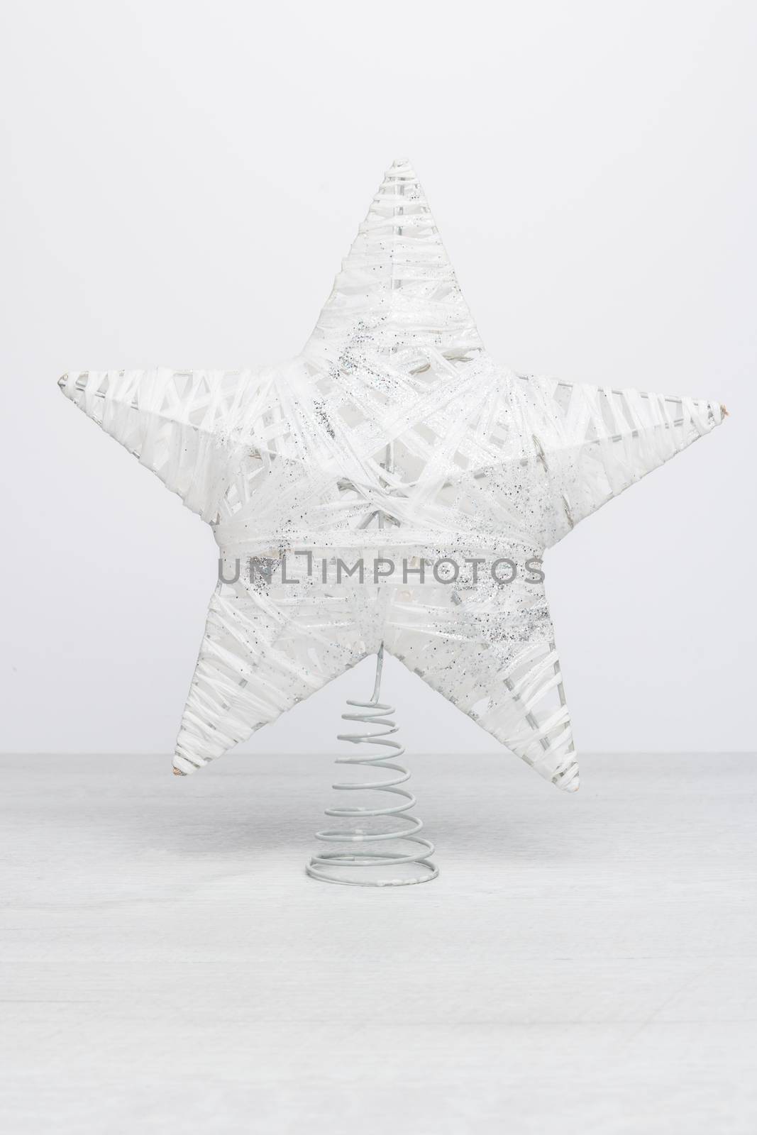 White glittering star shaped Christmas. Ornament on rustic white table background