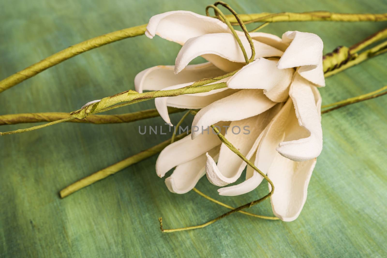 Elegant spring flower, fake gardenia on rustic wooden table. For wedding background image.