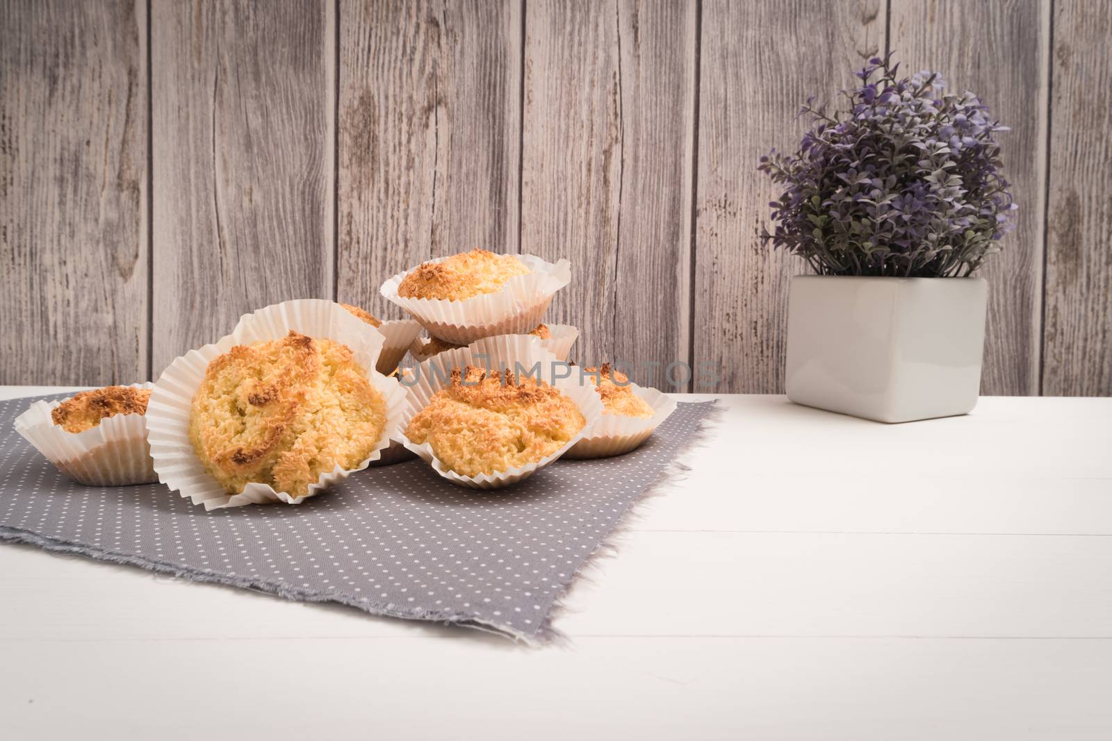 Close up of homemade coconut macaroons, cookie recipe in the oven on rustic wooden background.