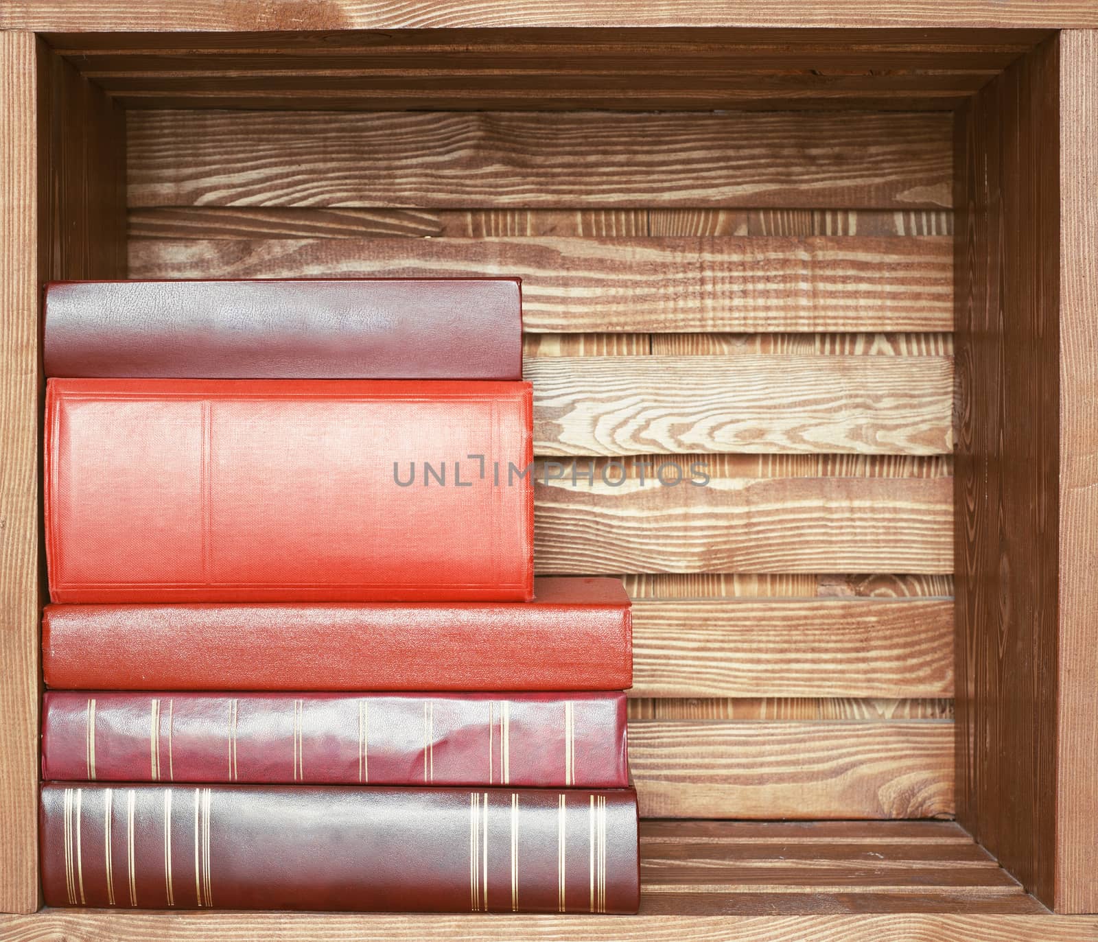 Old books on wooden brown plank shelf