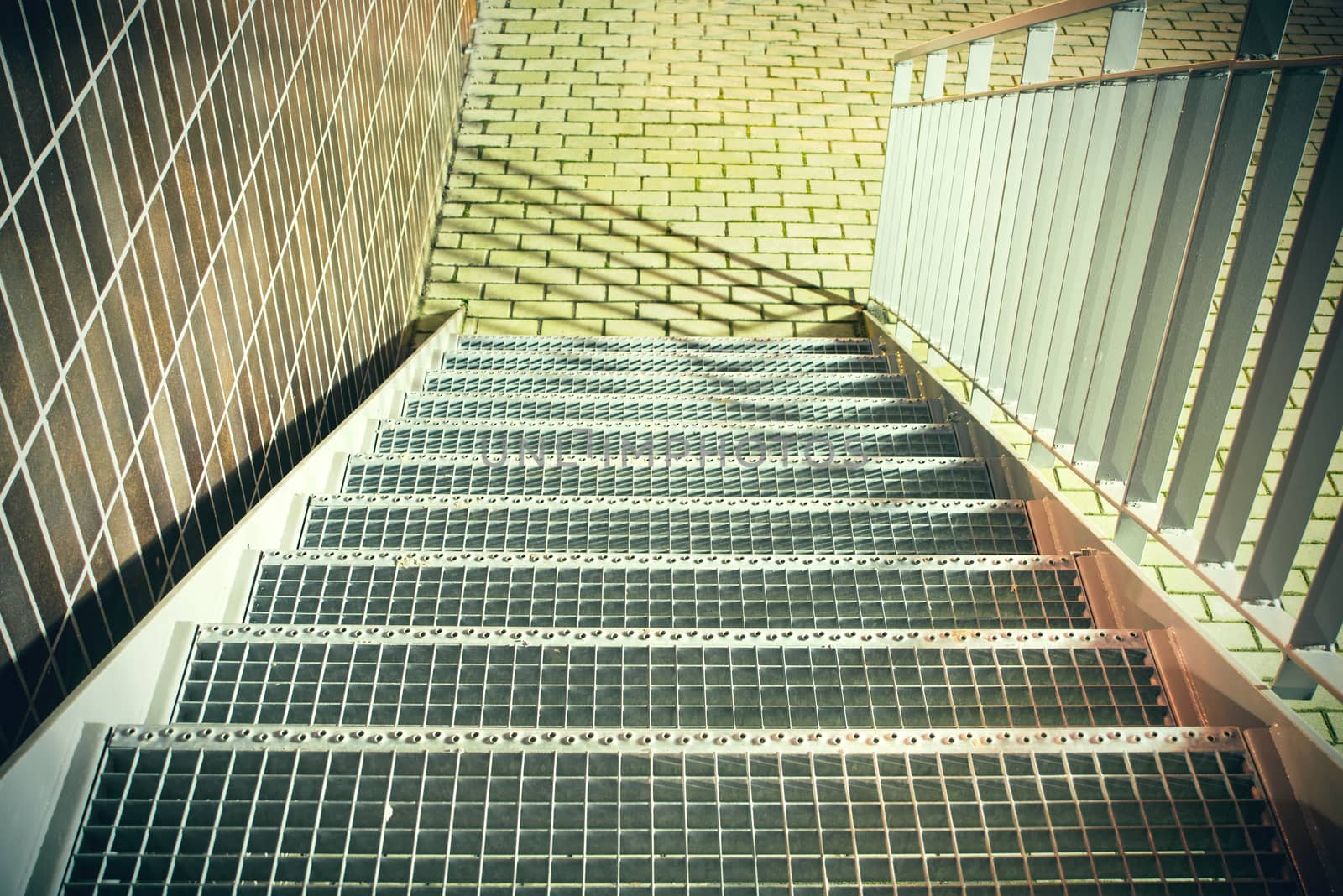 Metal stairs with railings, brick wall background