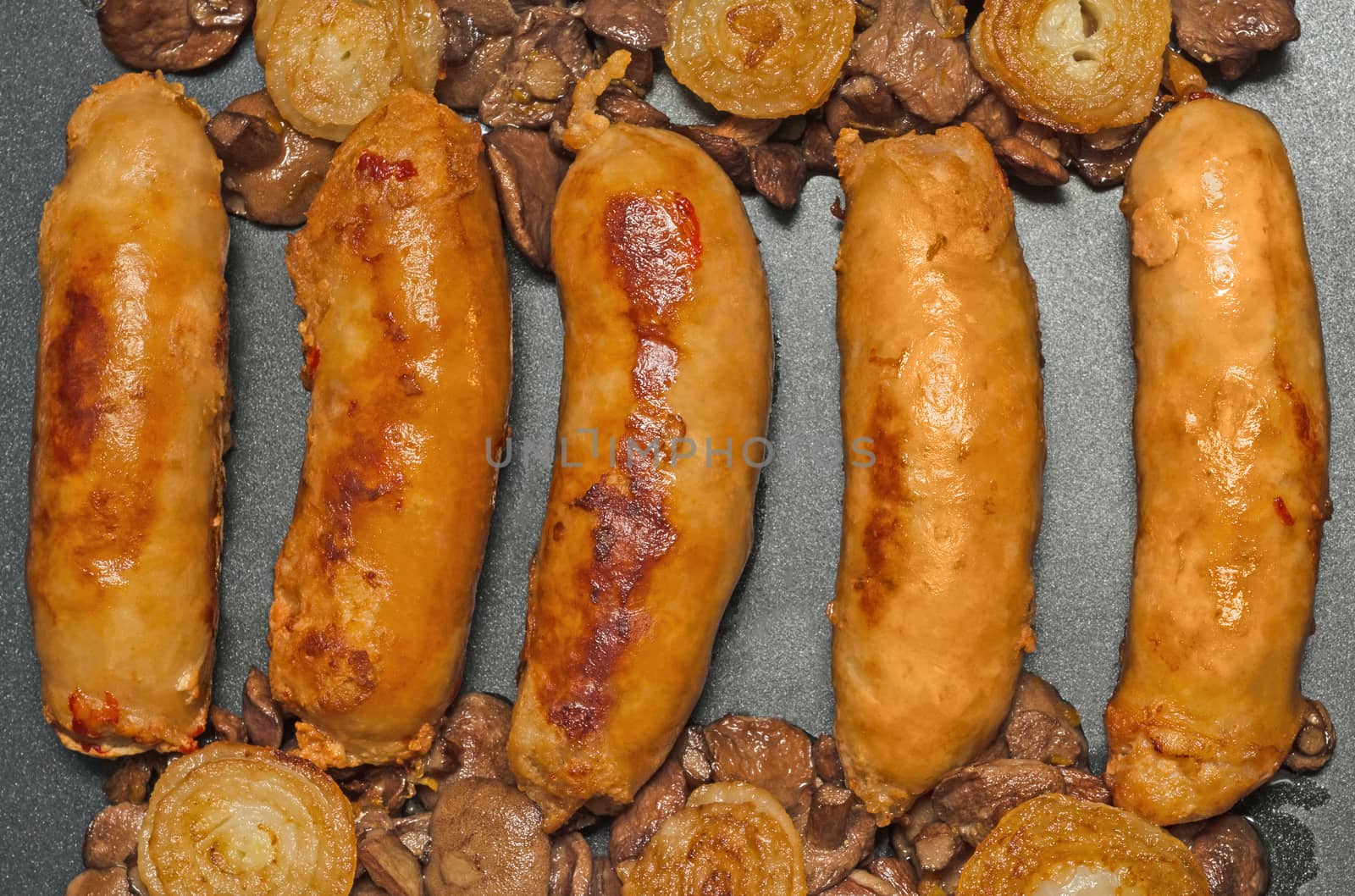 Fried homemade sausage with mushrooms and onions, lay on a baking sheet.