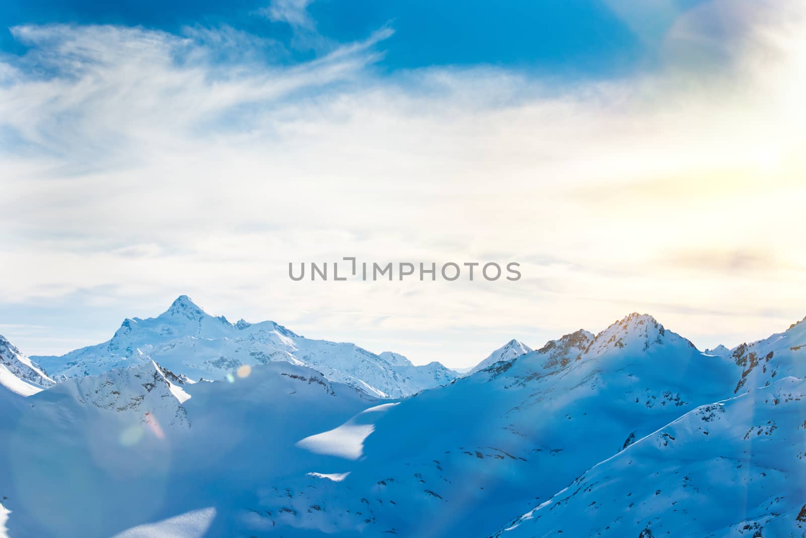 Snowy blue mountains in clouds. Winter ski resort