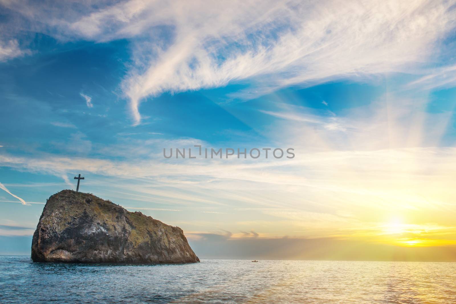 Sunset on the beach with sea, rocks and dramatic sky. Landscape with last rays of sun