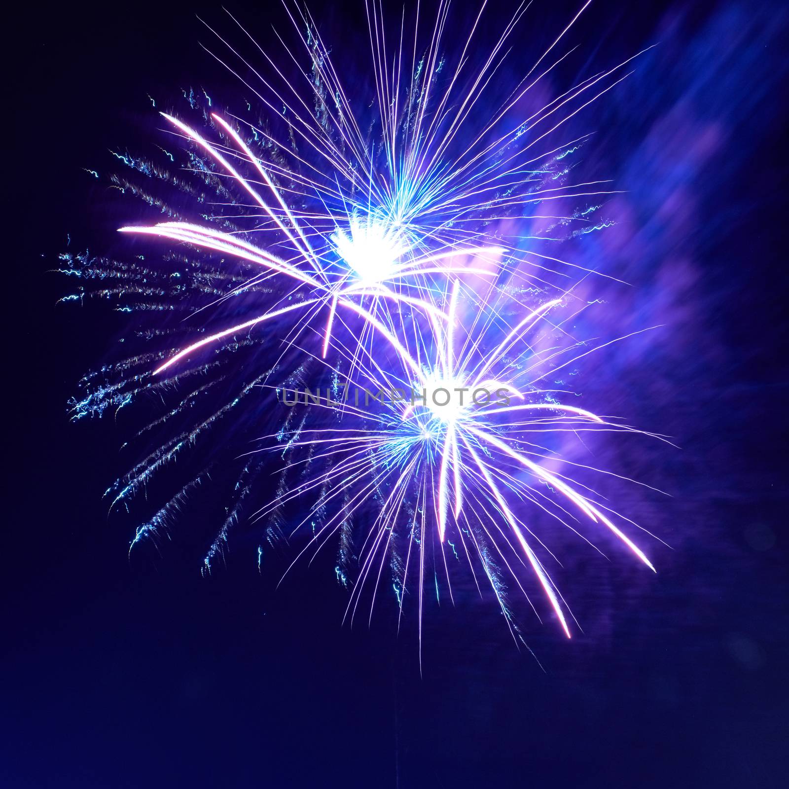 Blue colorful fireworks on the night black sky background. Holiday celebration.