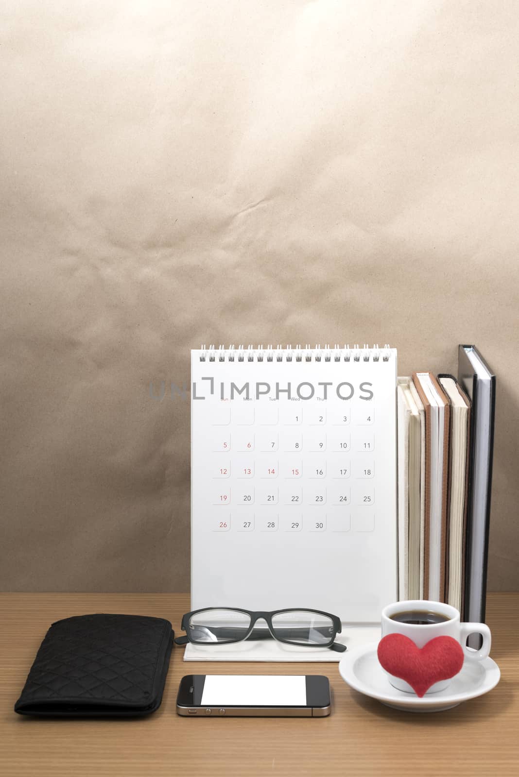 desktop : coffee with phone,stack of book,wallet,heart,eyeglasses,calendar on wood background